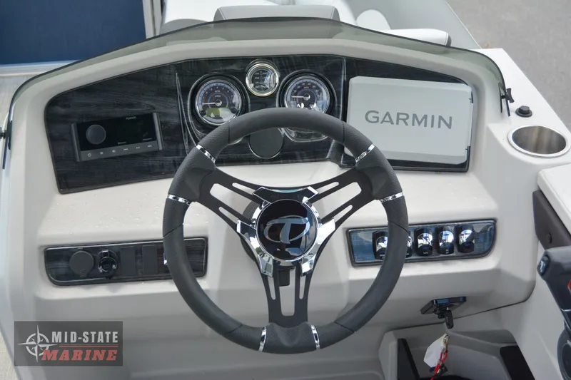 Slide: The Image of 2024 Tahoe Pontoon LTZ Quad Lounger dashboard with Garmin navigation system and steering wheel. - 11