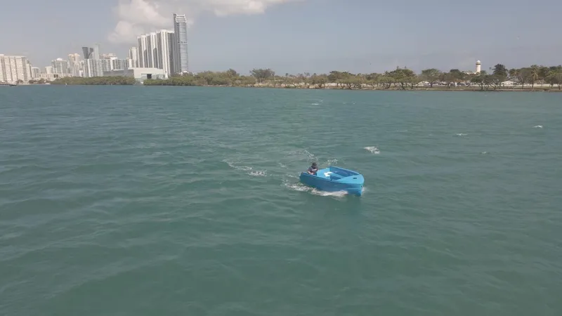 Slide: The Image of 2024 Vision Marine Technologies Phantom boat cruising on a calm urban waterfront. - 5