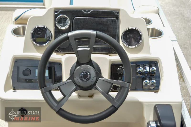 Slide: The Image of 2024 Tahoe Pontoon Sport 85 Quad Lounger steering console with gauges and controls. - 11