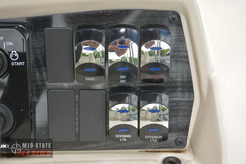 Slide: The Image of 2024 Tahoe Pontoon Sport 85 Quad Lounger control panel with radio, navigation, and light switches. - 27