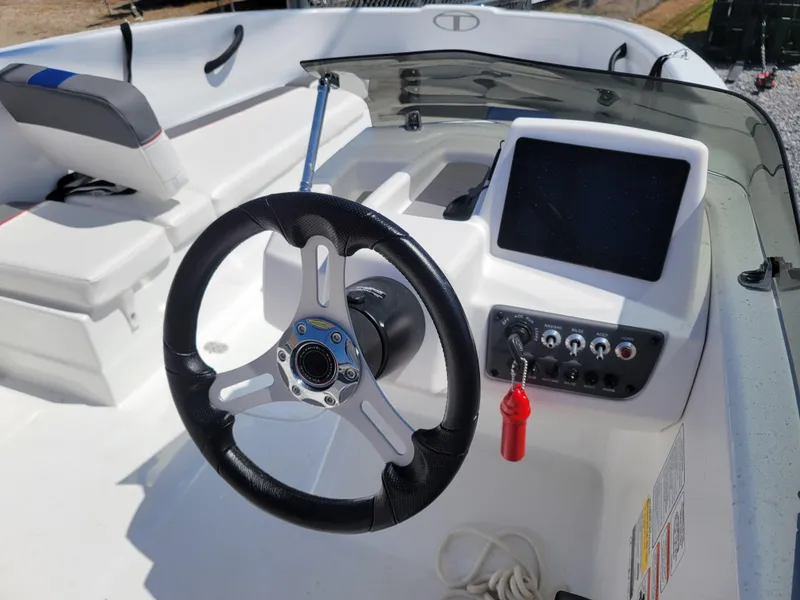 Slide: The Image of 2024 Tahoe T16 boat dashboard with steering wheel and control panel. - 11