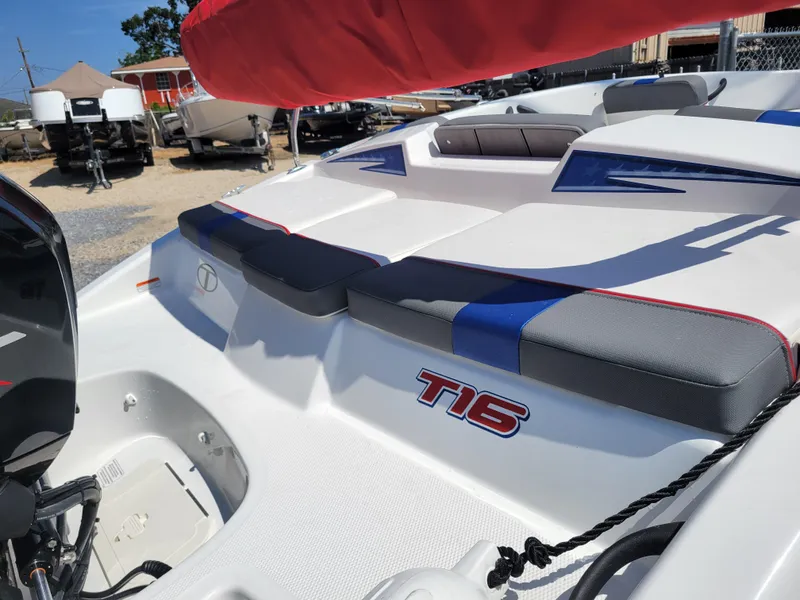 Slide: The Image of 2024 Tahoe T16 boat with cushioned seating and outboard motor in a dealership lot. - 12