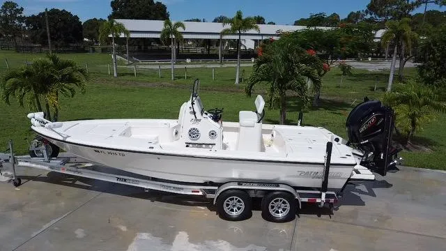 Slide: The Image of 2022 Pathfinder 2300 HPS boat on a trailer in a tropical setting. - 0