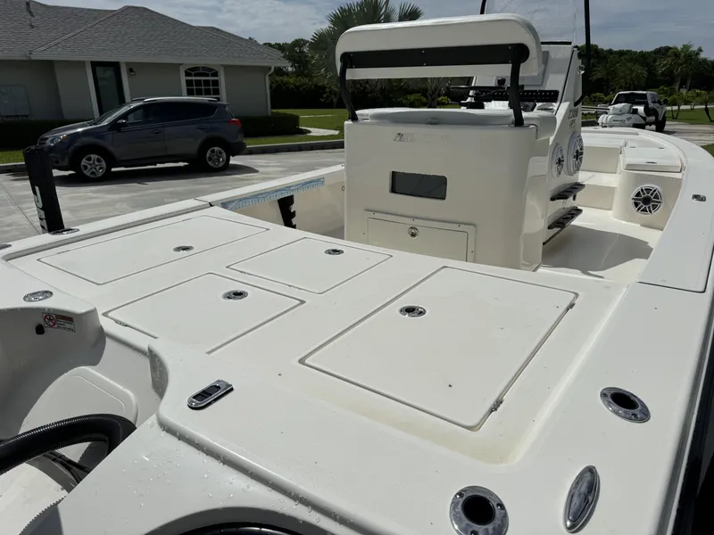 Slide: The Image of 2022 Pathfinder 2300 HPS boat, spacious deck, and modern console in a residential driveway. - 12