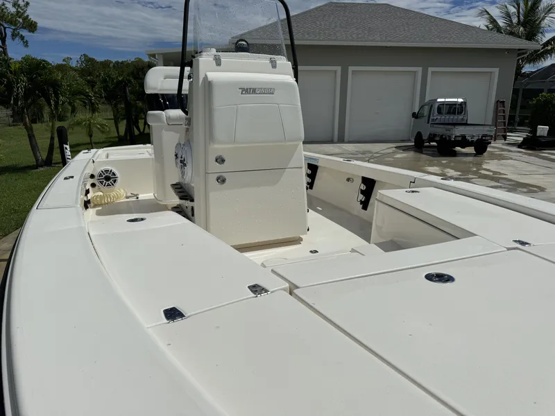 Slide: The Image of 2022 Pathfinder 2300 HPS boat in driveway, white exterior, near a garage. - 16