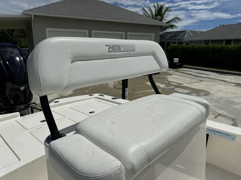 Slide: The Image of 2022 Pathfinder 2300 HPS boat seat with white upholstery in a sunny outdoor setting. - 18