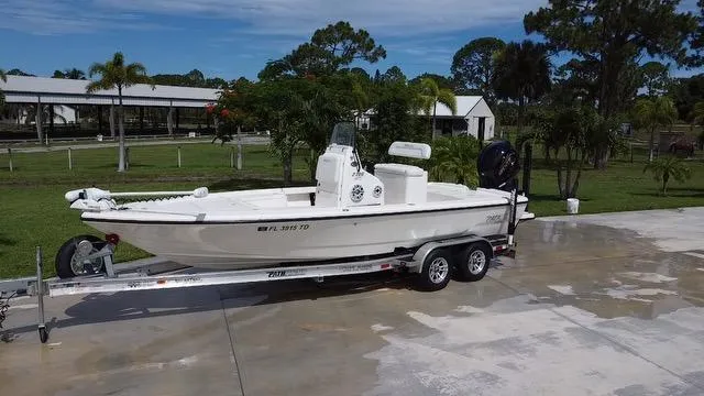 Slide: The Image of 2022 Pathfinder 2300 HPS boat on a trailer in a driveway. - 2