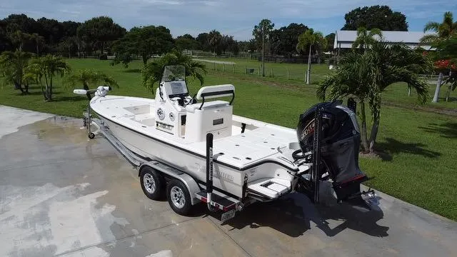 Slide: The Image of 2022 Pathfinder 2300 HPS boat on a trailer in a driveway, surrounded by greenery. - 3