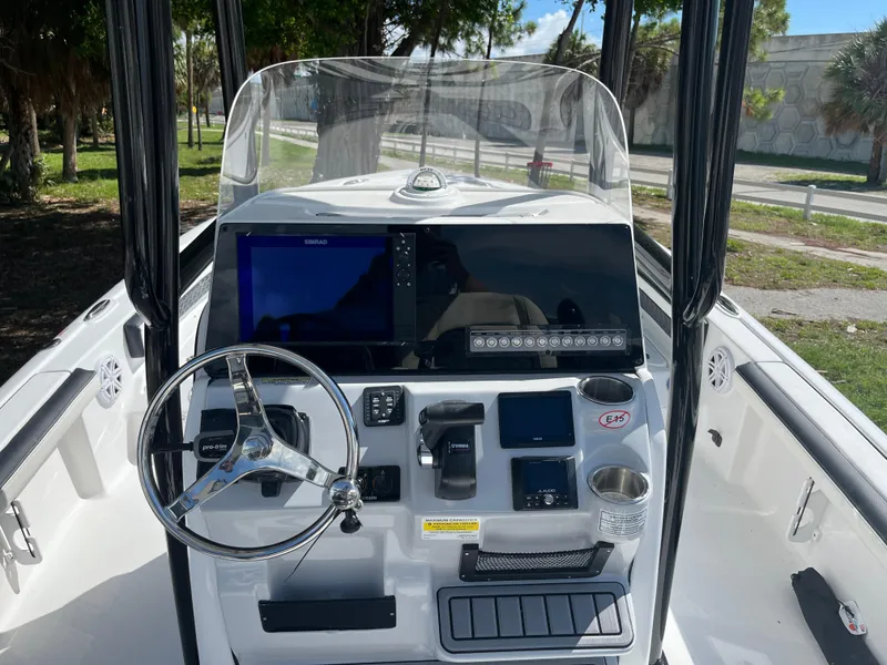 Slide: The Image of 2025 Tidewater 2300 Carolina Bay boat dashboard with steering wheel and electronic controls. - 9