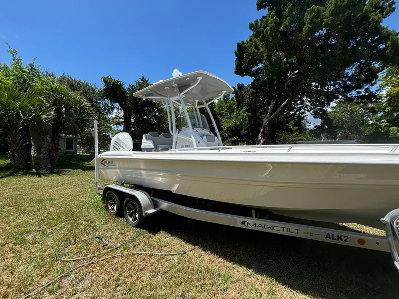 Slide: The Image of 2023 ALK2 Powerboats 25 CRX on trailer, parked on grass, surrounded by trees. - 4