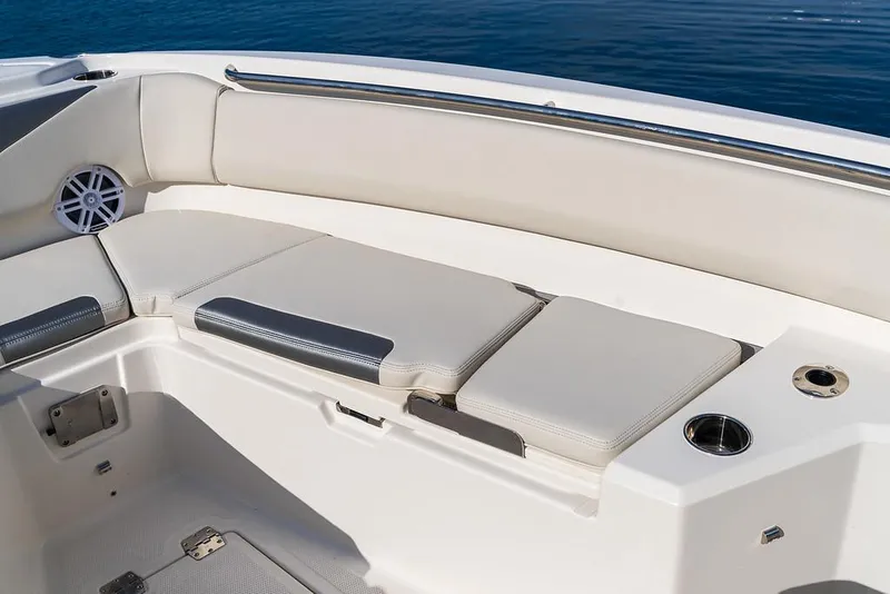 Slide: The Image of 2025 Sailfish 232 CC boat interior seating with cup holder and speaker. - 2