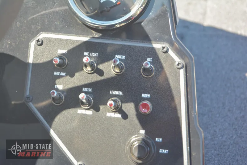 Slide: The Image of Control panel of 2024 Lowe Stinger 195 Bass boat with various switches and gauges. - 23