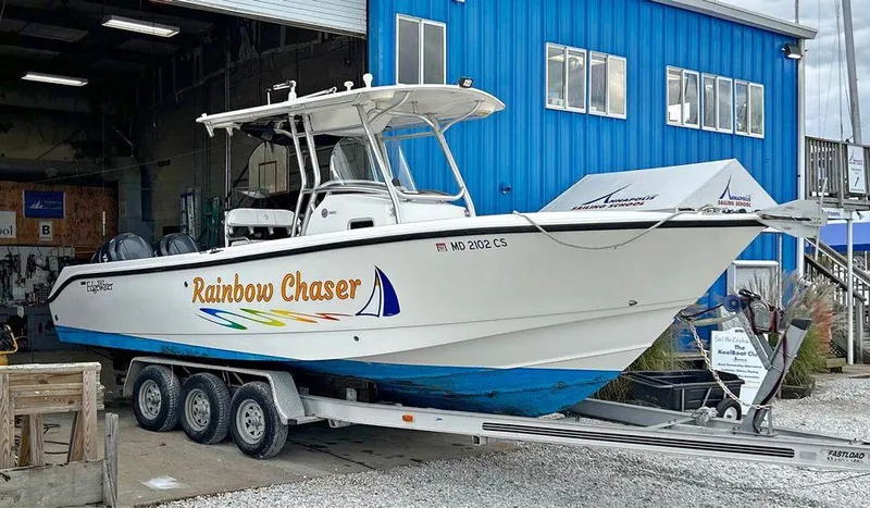 Slide: The Image of 2007 Edgewater 268CC Rainbow Chaser boat on trailer outside blue building. - 0