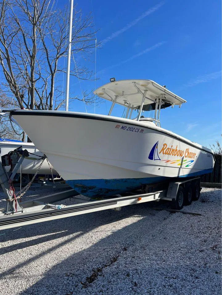 Slide: The Image of 2007 Edgewater 268CC boat Rainbow Chaser on a trailer, parked on gravel. - 1