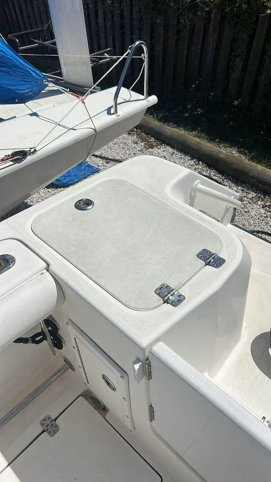 Slide: The Image of 2007 Edgewater 268CC boat deck with storage compartments and clean white finish. - 10