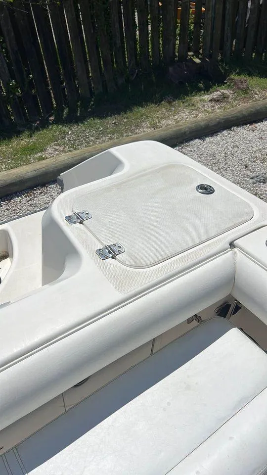 Slide: The Image of 2007 Edgewater 268CC boat interior with white cushioned seating and storage compartment. - 11