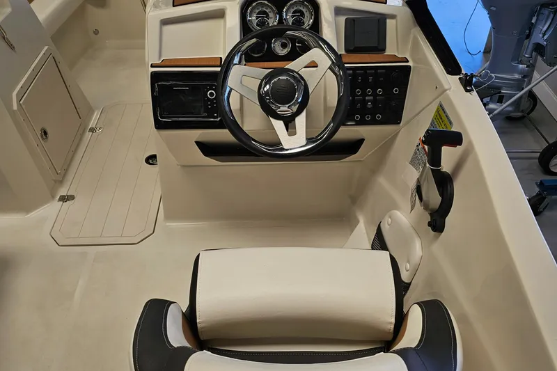Slide: The Image of 2024 Starcraft SVX 210 OB DC boat cockpit with steering wheel and control panel. - 6