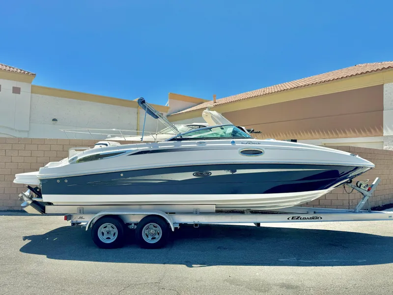 The Image of 2012 Sea Ray 260 SD boat on trailer, parked outdoors under clear blue sky. - 0