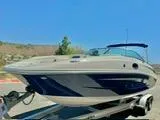 Slide: The Image of 2012 Sea Ray 260 SD boat on trailer, parked outdoors under clear blue sky. - 3