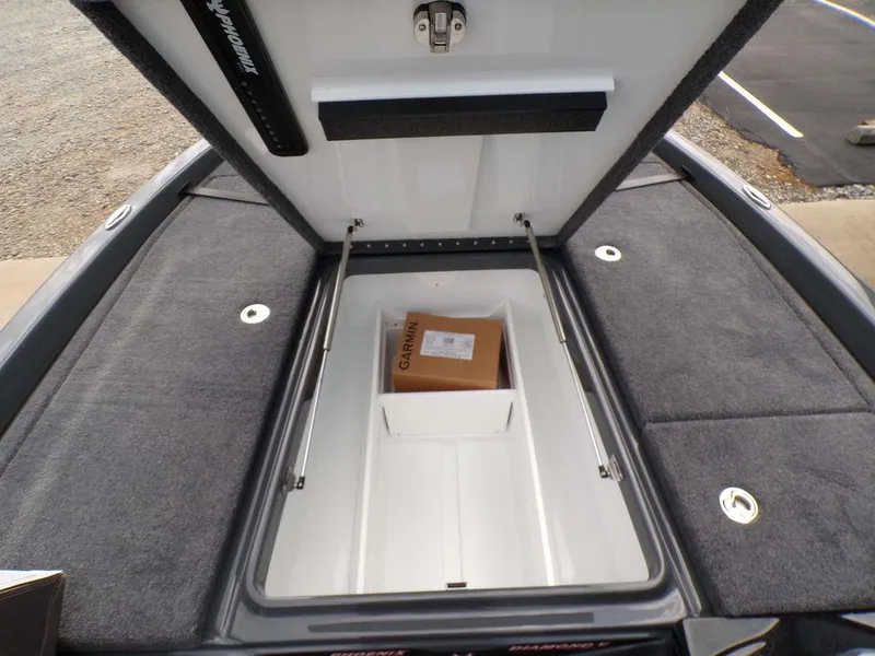 Slide: The Image of Open storage compartment in 2025 Phoenix 920 Elite boat with a Garmin box inside. - 16