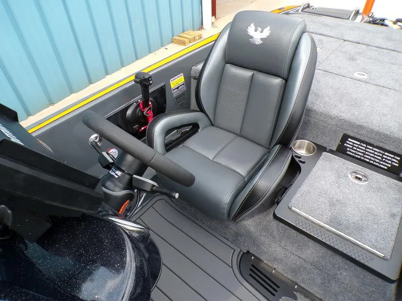 Slide: The Image of Phoenix 920 Elite 2025 boat interior with steering wheel and cushioned seat. - 23