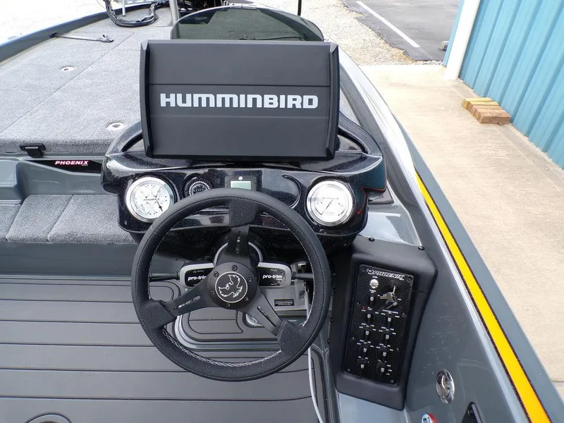 Slide: The Image of Phoenix 920 Elite 2025 boat dashboard with Humminbird display and steering wheel. - 24