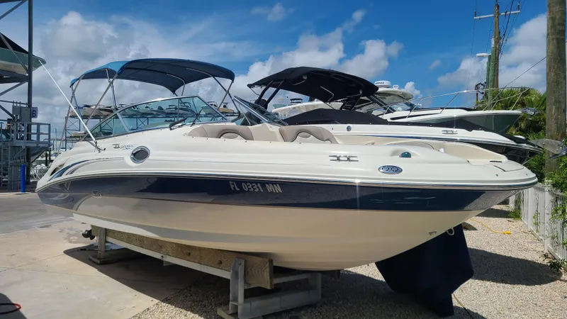 The Image of 2004 Sea Ray 270 Sundeck boat on a trailer under a clear blue sky. - 0