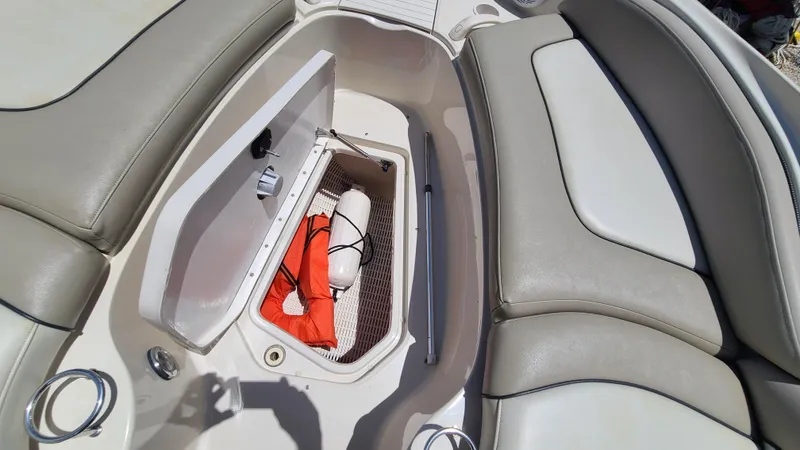 Slide: The Image of Storage compartment on a 2004 Sea Ray 270 Sundeck boat with safety equipment. - 27