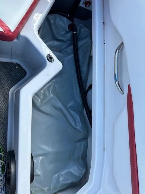 Slide: The Image of 2016 Scarab 215 HO Impulse boat storage compartment with red and white interior. - 14
