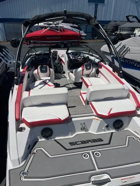 Slide: The Image of 2016 Scarab 215 HO Impulse boat with red and white interior, docked at a marina. - 6