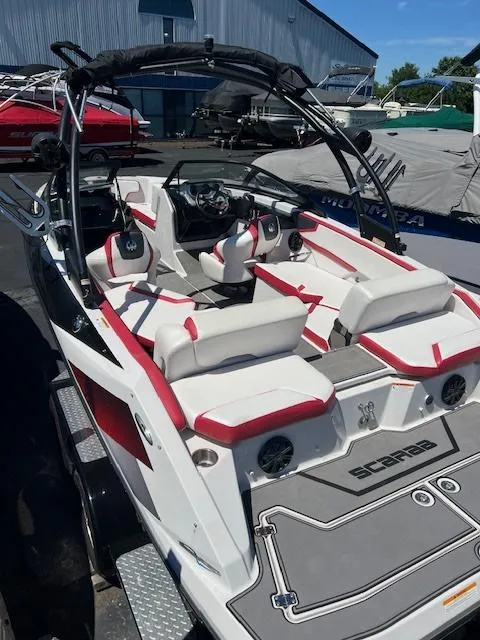 Slide: The Image of 2016 Scarab 215 HO Impulse boat with red and white interior, docked at a marina. - 7