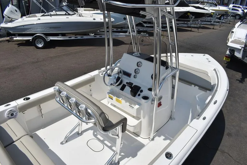 Slide: The Image of 2024 Key West 189 FS boat interior with console and seating, parked in a marina. - 8