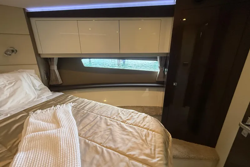 Slide: The Image of Interior of 2020 Carver C37 Coupe, featuring a cozy bedroom with window view. - 36