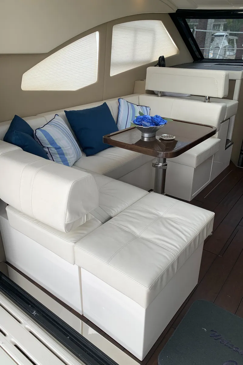 Slide: The Image of 2020 Carver C37 Coupe interior with white leather seating and blue accent pillows. - 17