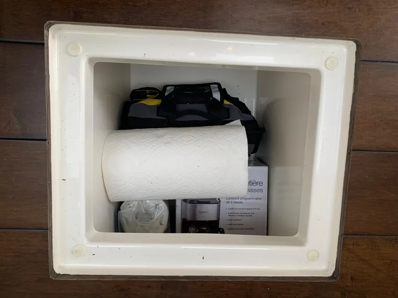 Slide: The Image of Storage compartment in 2020 Carver C37 Coupe with paper towel roll and bag. - 21