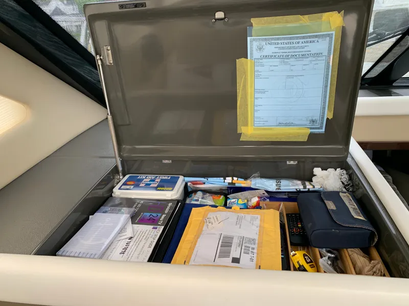 Slide: The Image of 2020 Carver C37 Coupe interior storage compartment with documents and supplies. - 26