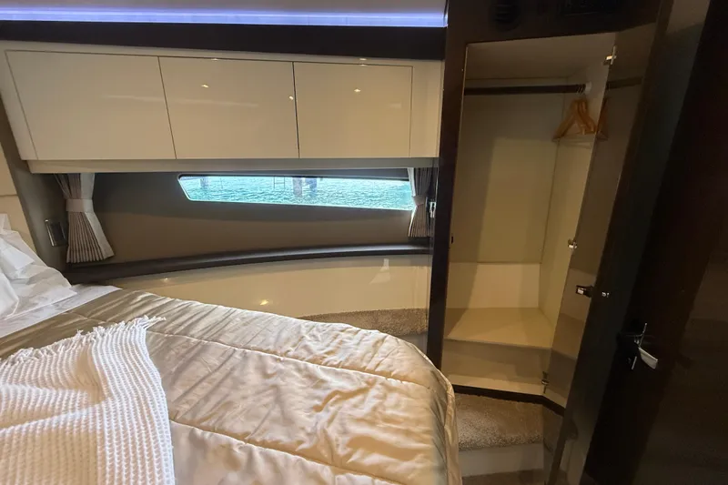 Slide: The Image of Interior of 2020 Carver C37 Coupe bedroom with bed, closet, and window view. - 37