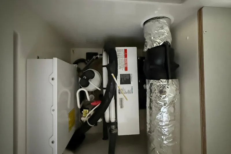 Slide: The Image of 2020 Carver C37 Coupe interior mechanical components, featuring ductwork and wiring. - 50