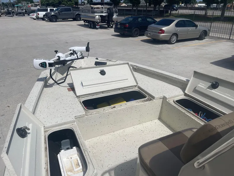 Slide: The Image of 2018 Express H20 Bay boat with open storage compartments in a parking lot. - 12