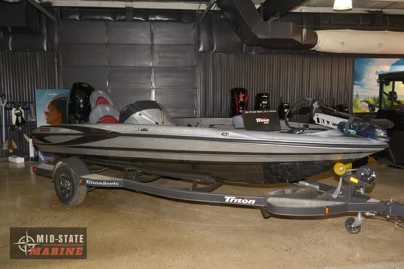 Slide: The Image of 2024 Triton 18 TrX bass boat displayed at Mid-State Marine showroom. - 0