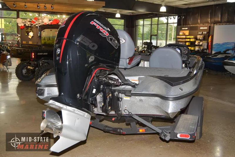 Slide: The Image of 2024 Triton 18 TrX boat with powerful outboard motor displayed at Mid-State Marine showroom. - 21