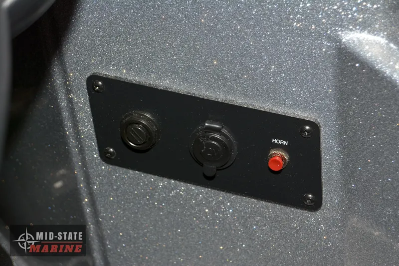 Slide: The Image of Control panel of 2024 Triton 18 TrX boat with horn button and power outlets. - 7