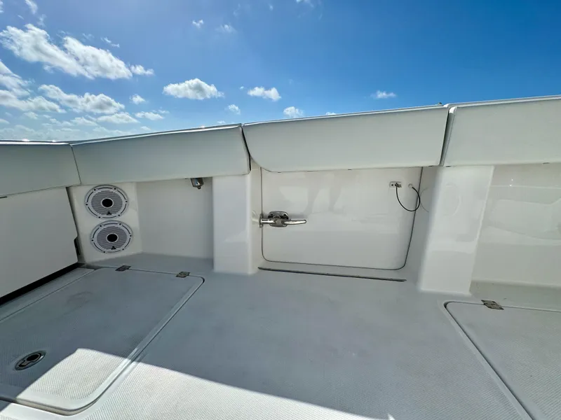 Slide: The Image of 2022 Invincible 40 Catamaran deck with storage compartments and speakers under a clear blue sky. - 14