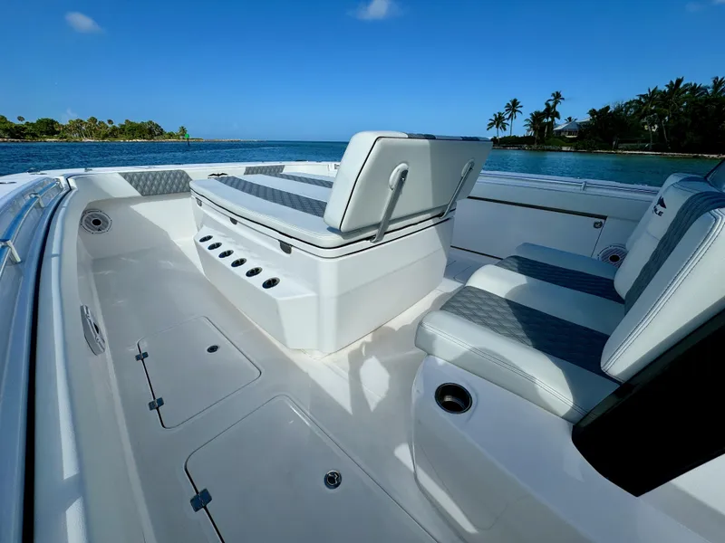 Slide: The Image of 2022 Invincible 40 Catamaran interior with seating, ocean view, and tropical background. - 18