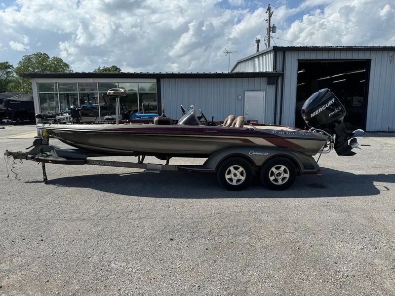 Slide: The Image of 2001 Ranger 520DVX Comanche boat on trailer, parked outside a garage under a cloudy sky. - 3