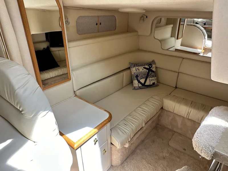Slide: The Image of 1999 Sea Ray 340 Sundancer interior with beige seating and nautical-themed decor. - 7