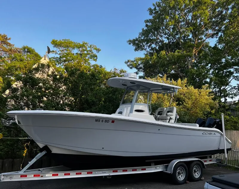 Slide: The Image of 2021 Cobia 262 Center Console boat on trailer, parked outdoors. - 3