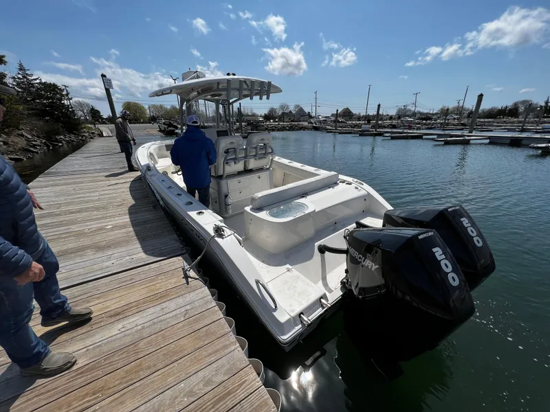 Slide: The Image of 2021 Cobia 262 Center Console boat docked with twin Mercury 200 engines. - 4