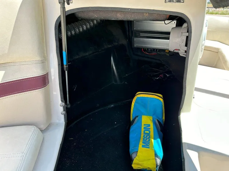 Slide: The Image of 1999 Centurion Elite-V C4 boat interior storage with a blue and yellow bag. - 20