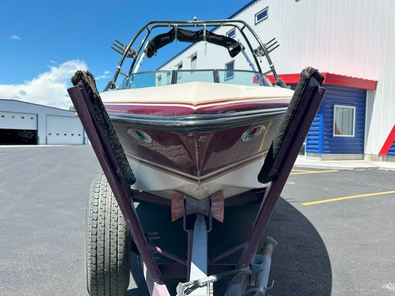 Slide: The Image of 1999 Centurion Elite-V C4 boat on trailer, parked near industrial buildings. - 3